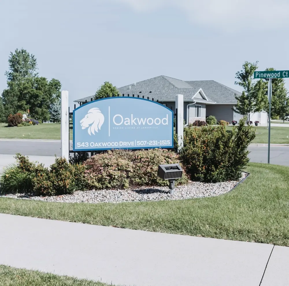 Blue Oakwood sign in a landscaped island at the entrance