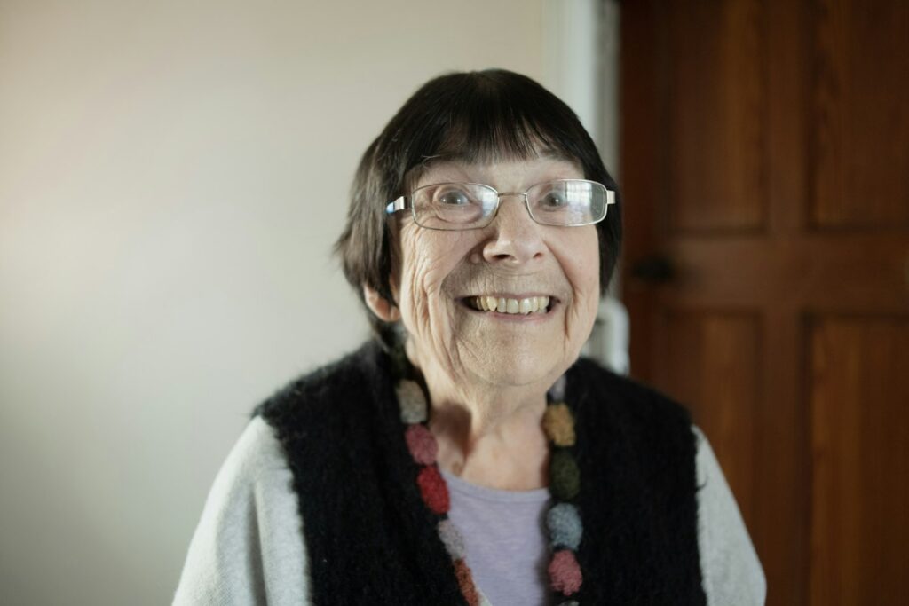 An older woman with glasses laughing